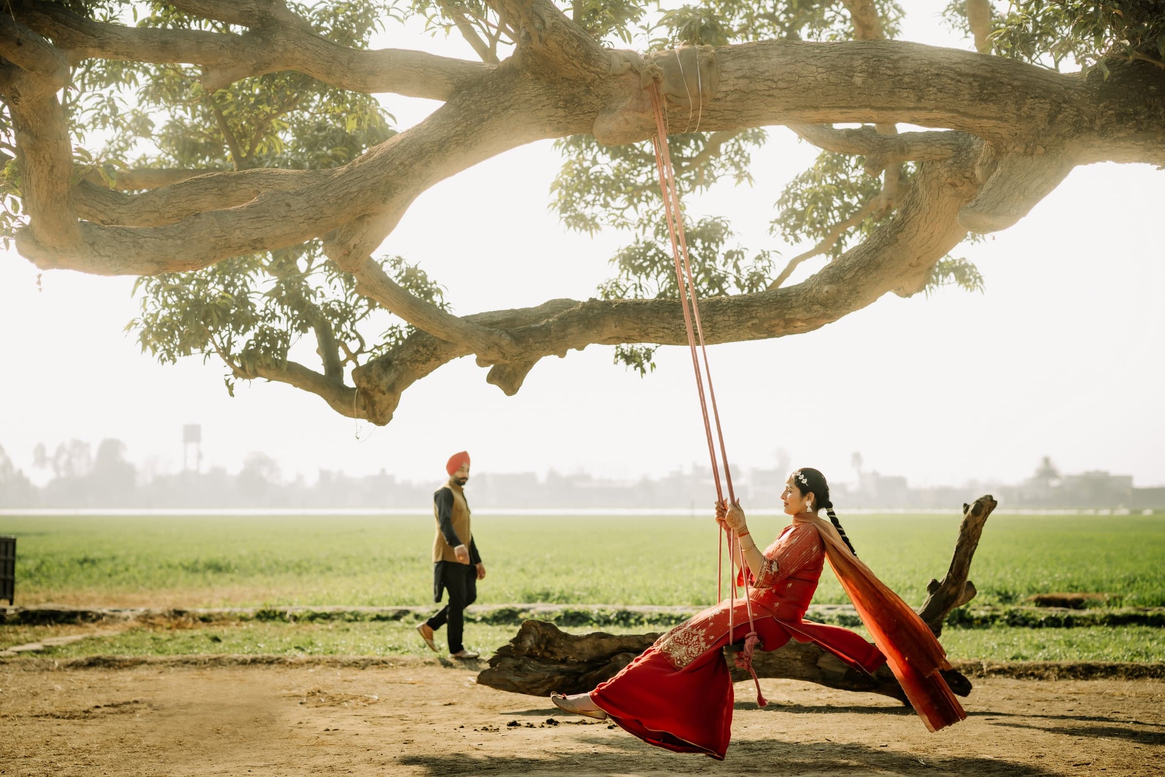 A couple sharing a quiet moment beneath a golden-hour tree canopy
