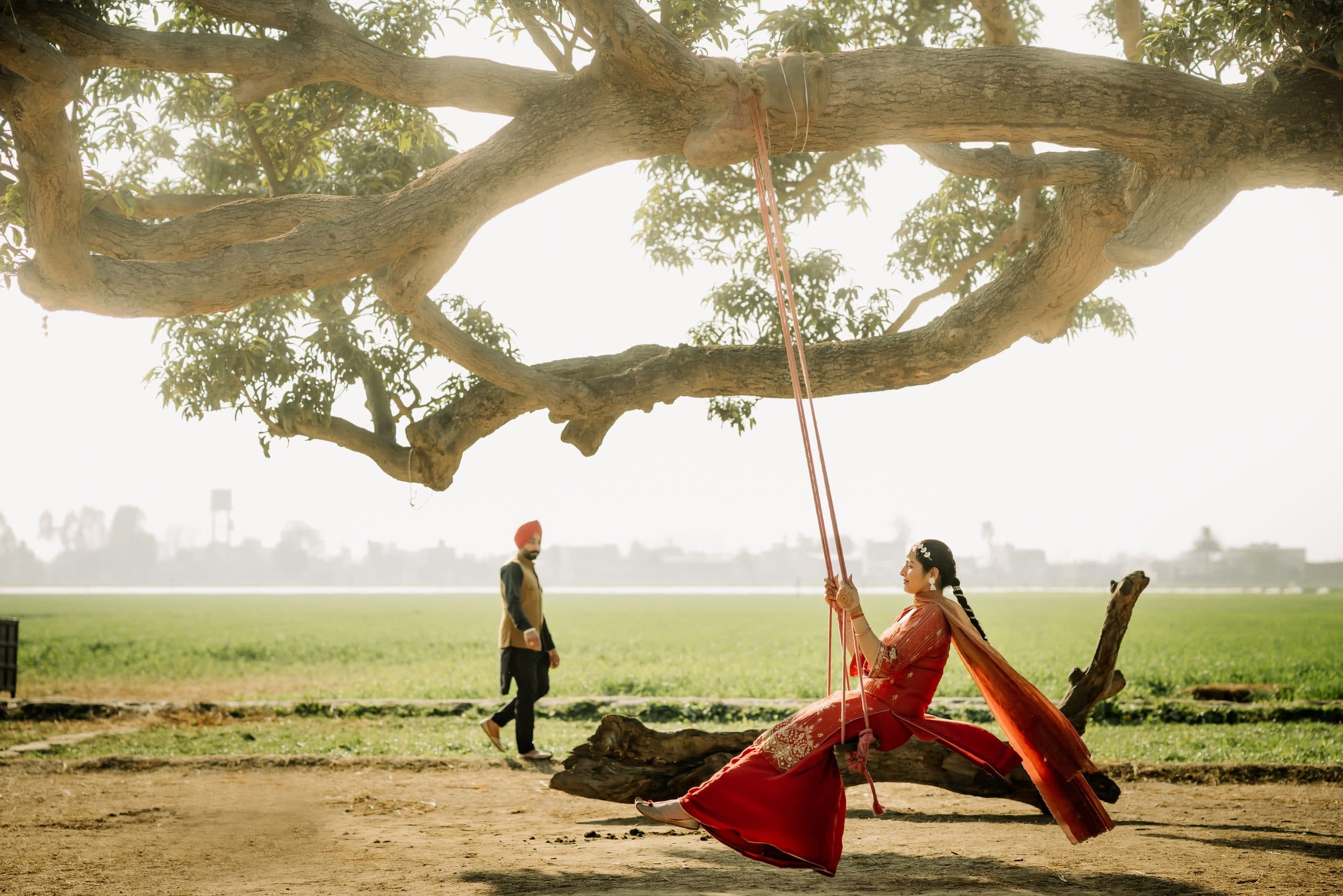 A couple walking through a sunlit heritage courtyard archway